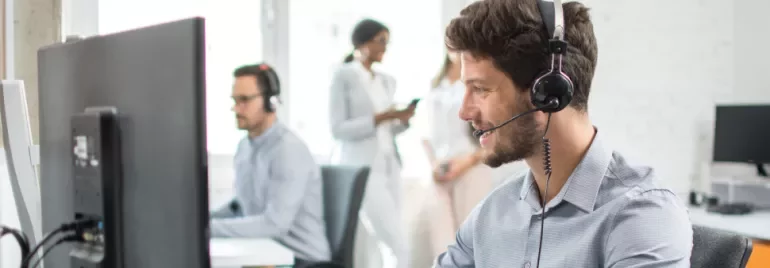 Customer service agent wearing a headset at a desk.